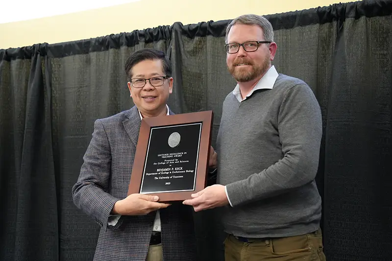 Benjamin Keck is presented with an award by Liem Tran at the Faculty Awards Ceremony
